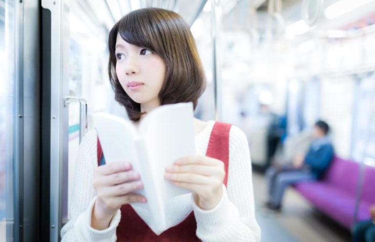 電車内でノートを持つ女性
